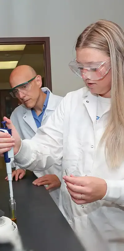 image of a student working on a lab experiment with a facult member